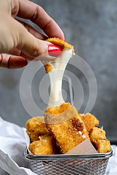 Mozzarella sticks melting with woman hand