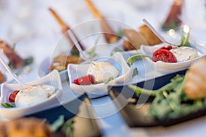 Mozzarella and tomato appetizers served in a white small plates during brunch food buffet