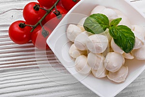 Mozzarella tomatoes and basil on a wooden rustic background