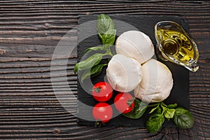 Mozzarella tomatoes and basil on a wooden rustic background