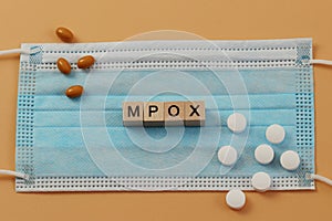 Mpox is laid out with wooden cubes on a surgical face mask. photo