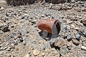 Rusty soda can on stony soil photo