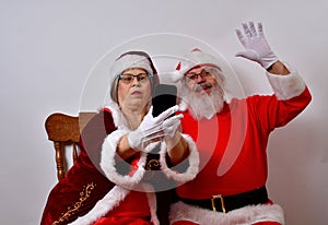 Mr and Mrs Santa Claus having fun using a smart pone