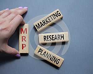 MRP - Marketing Research Planning symbol. Concept word MRP on wooden cubes. Businessman hand. Beautiful grey background. Business