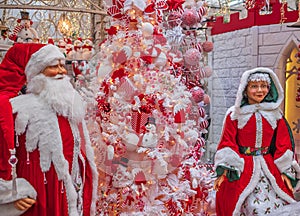 Mrs. Santa and her husband Santa Claus greeting the guests at the entery of a house. Smiling Santa Claus and Mrs. Santa