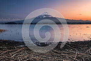 Mt Fuji with lake and stone foreground in Kawaguchiko lake, Japan at sunset