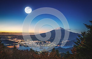 Mt. Fuji over Lake Kawaguchiko with autumn foliage and fullmoon at sunrise in Fujikawaguchiko, Japan