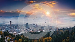 Mt. Hood and Portland downtown with rolling fog and autumn foliage in shining sunrise and colorful clouds