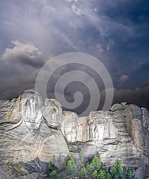 Mt. Rushmore national memorial park in South Dakota at night, presidents faces illuminated against black sky