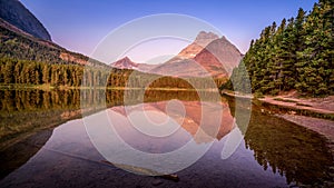 Mt. Wilbur reflection in the smooth surface of Fishercap Lake at sunrise in Glacier National Park photo