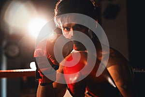 Muay Thai boxer punch his fist in front of camera posing. Impetus