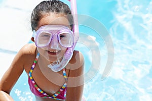 This is so much fun. Portrait of a little girl wearing snorkeling equipment and standing in a pool.