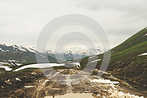 Mud Dirt Road in the Caucasus mountains and snow photo