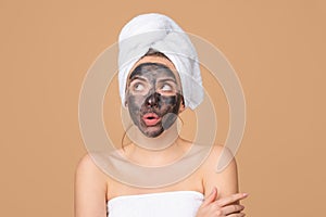 Mud facial mask, face clay mask spa. Beautiful funny woman with cosmetic mud facial procedure, spa health concept. Skin