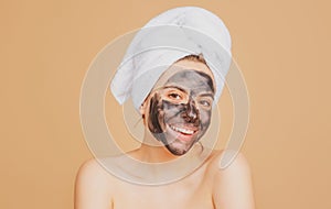 Mud facial mask, face clay mask spa. Beautiful smiling woman with cosmetic mud facial procedure, spa health concept