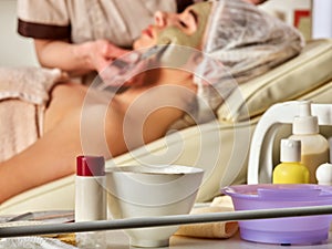 Mud facial mask of woman in spa salon. Face massage .