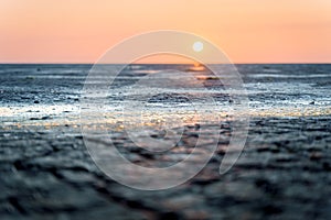 Mud flat of the \'waddenzee\' during low tide under scenic Sundown sky, The Netherlands