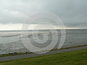 The mud flats on the waddensea with a dark cloud field