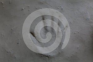 A mud plastered wall with hand print or hand impression on it