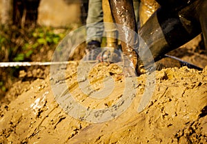 Mud race runners, defeating obstacles. Details of the hands