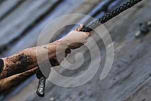 Mud race runners, defeating obstacles by using rope