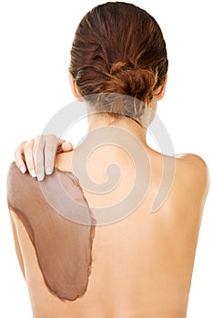 Mud therapy is great for the skin. Studio shot of a young woman with a mud treatment on her back.
