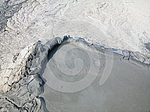 Mud volcano flowing down clayey mud mixed with hydrocarbons.