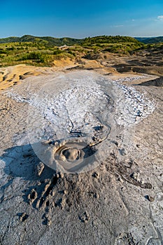 Mud volcano with gas bubble, muddy wet geology, lunar landscape, Berca, Romania