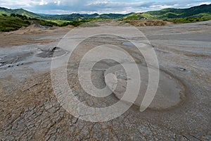 Mud volcanoes in Romania near the village of Berca Paclele Mici with greenery in the background