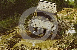 Mud and water splash in off the road racing. Tracks on a muddy field. Off-road vehicle goes on mountain way. Expedition
