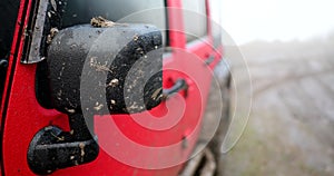 Muddy car mirror on off road steppe adventure trail