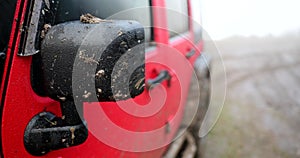 Muddy car mirror on off road steppe adventure trail