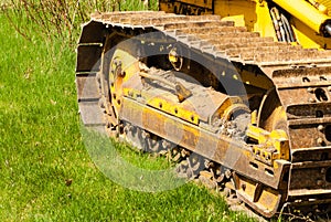 Muddy caterpillar tracks on bulldozer.