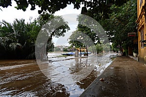 A muddy flooded street in downtown Hoi An, Vietnam along the Thu Bon River during the 2021 rainy season