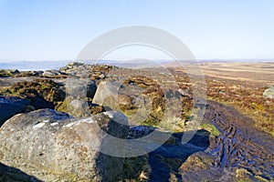 Muddy footpath leads off  Stanage Edge on a misty winter morning