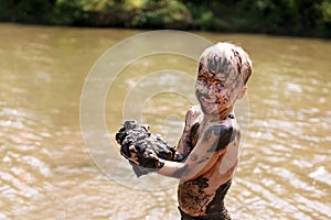 Muddy Little Boy Child Laughing as He Swims and Plays Outside in River