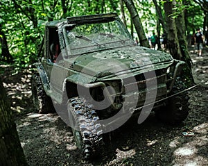 Muddy military jeep in forest