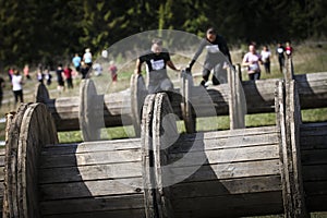 Muddy obstacle race runner in action. Mud run