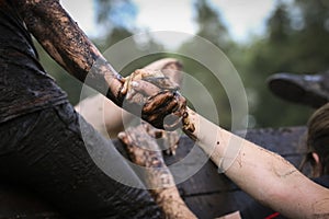 Muddy obstacle race runner in action. Mud run