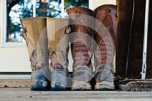 Muddy snake hunting boots on doorstep.
