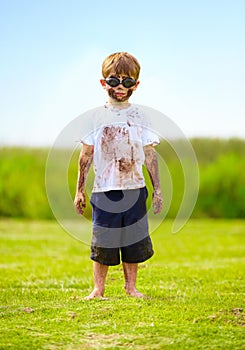 A muddy superhero. A little boy dressed as a superhero and covered in mud.
