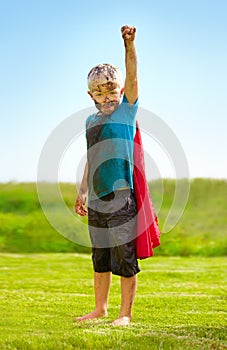 A muddy superhero. A little boy dressed as a superhero and covered in mud.