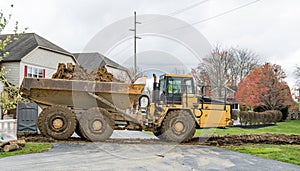 Muddy Truck Hauling Excavated Dirt from Construction Side