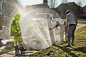 Muddy utility worker men fixing broken water line