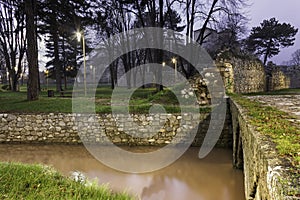 Muddy water in the channel around city park and ancient fortress