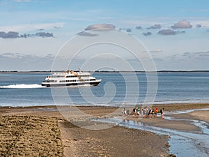 Mudflat hiking and ferry in WittdÃÂ¼n channel, Amrum island, North Frisia, Schleswig-Holstein, Germany