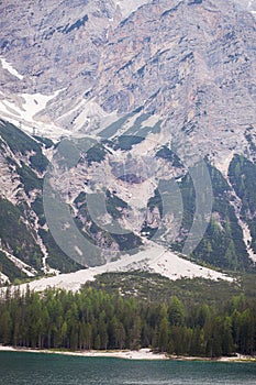 Mudflow with snow high in the Alpine mountains lake, Lago Di Braies photo