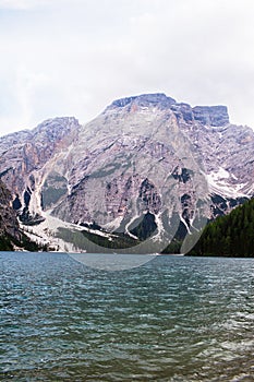 Mudflow with snow high in the Alpine mountains lake, Lago Di Braies photo