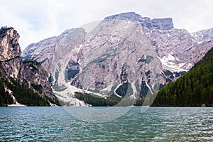 Mudflow with snow high in the Alpine mountains lake, Lago Di Braies