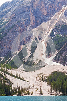 Mudflow with snow high in the Alpine mountains lake, Lago Di Braies photo